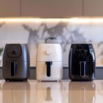 Drei markenfreie Airfryer auf einer modernen Küchenarbeitsfläche als Symbolbild für verschiedene Airfryer-Bauformen.
