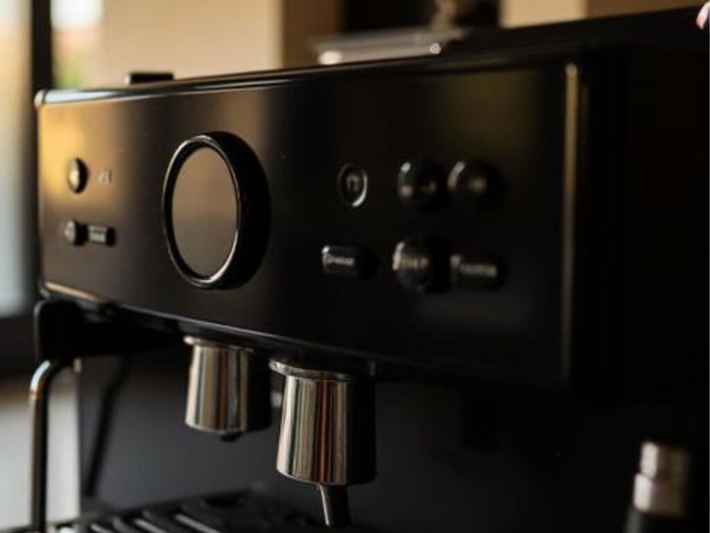 Detailansicht eines Kaffeevollautomaten mit Bedienfeld, Drehregler und Kaffeeauslauf